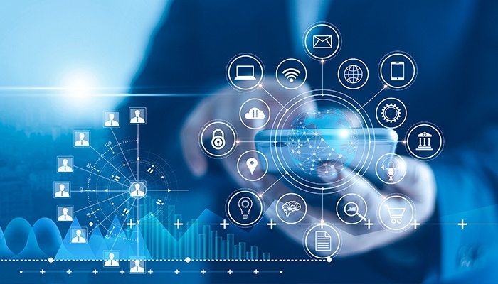 Ein Mann steht hinter einem transparenten Bildschirm und drückt mit dem Zeigefinder auf einem Mobiltelefon.